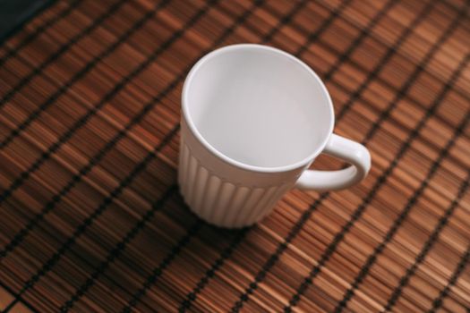 white mug on a wooden stand stands on the table top view. High quality photo