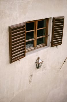 Wooden window made of brown wood and open window shutters