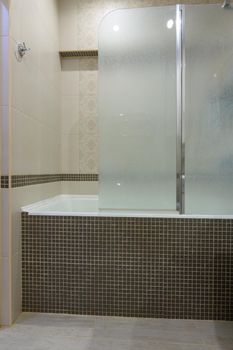 The bathroom is separated from the bathroom by a glass partition, the partition door is closed