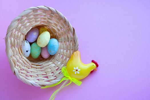 An overturned basket in the shape of a hat with eggs on a pink background. Easter Concept. Space for your text.