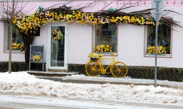 Vintage style flower shop, yellow bicycle with basket and daffodils.