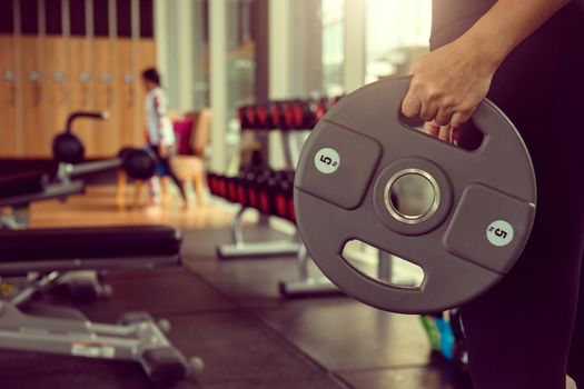 Young woman lifting weights on training class at gym. Concept fitness ,workout, gym exercise ,lifestyle and healthy.