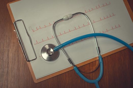 Close-up cardiogram with stethoscope on wooden table. Health  Concepts