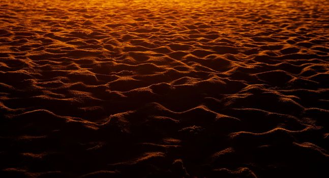 closeup of sand pattern of a beach in the sunset.