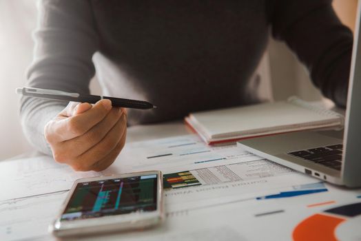 Businesswoman analyze business report graph and finance chart at corporate office. Concept of finance economy, banking business and stock market research.