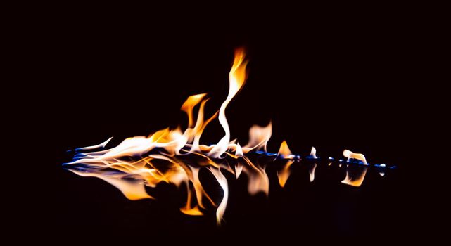 Beautiful flame with reflection on a black background.