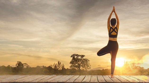 Young woman practicing yoga in the nature.female happiness. Pose balance body vital zen and meditation for workout nature mountain background in morning day. Copy space for banner.