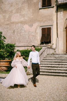 The wedding couple walks in the garden. Lovers of the bride and groom. Wedding in Florence, Italy, in an old villa-winery.