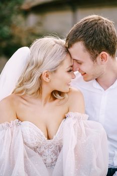 Close-up portrait of a wedding couple, the groom hugs the bride. Wedding at an old winery villa in Tuscany, Italy.