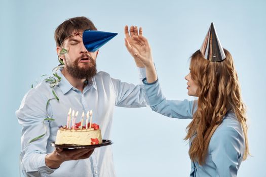 Emotional man with cake and pretty woman party disco blue background. High quality photo