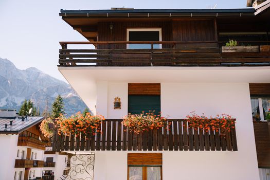 White whitewashed house, with wooden elements in northern Italy, in the Dolomites area, in a winter ski resort, in the city of Cortina Ampezzo.