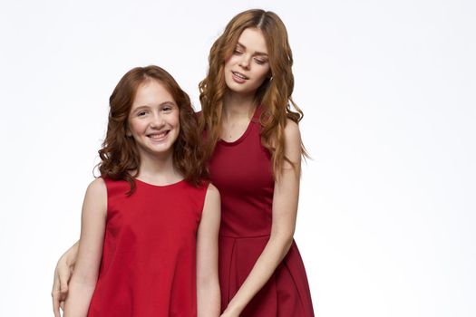 Mom and daughter stand side by side and fun family joy light background. High quality photo