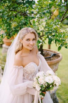 Wedding in Florence, Italy, in an old villa-winery. Bride with a bouquet in the garden, near the lemon tree.