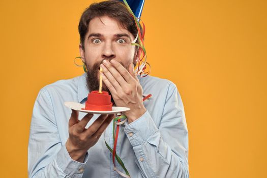Birthday boy in a cap with a birthday cake in his hand and a candle. High quality photo