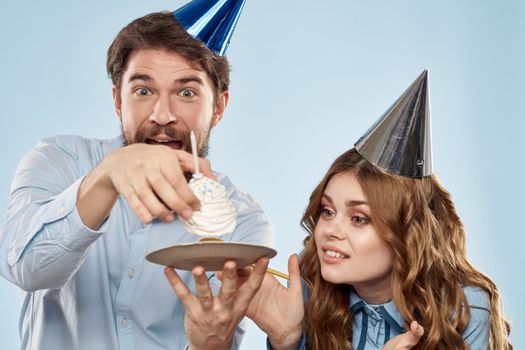 Birthday corporate young man and woman with cake on isolated background disco party. High quality photo