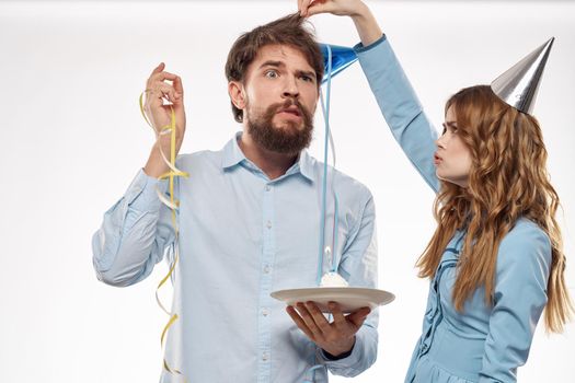 Cheerful man and woman with cake in a plate corporate party . High quality photo