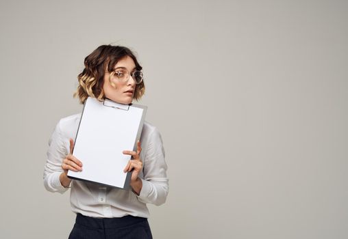 Woman in light clothes on gray background and white sheet of paper mockup Copy Space. High quality photo