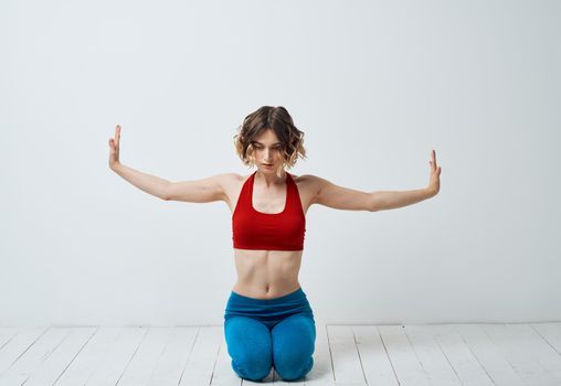 Woman in sportswear on a light background gestures with her hands yoga asana. High quality photo