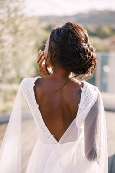 Destination fine-art wedding in Florence, Italy. The African-American bride stands with her back, in a white dress with a large neckline against the backdrop of Florence's urban landscape.