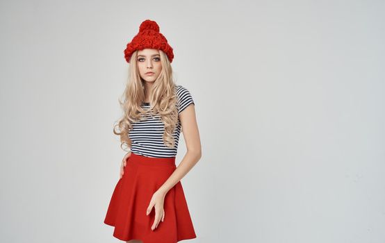 stylish blonde in a striped T-shirt and knitted hat gestures with her hands Copy Space. High quality photo