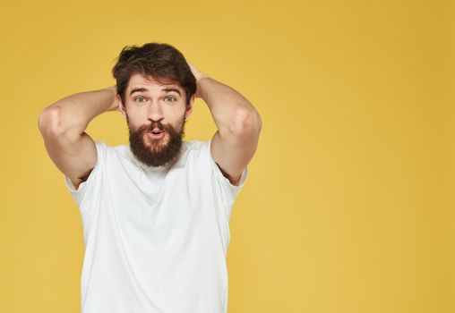 Portrait of a man on a yellow background gesturing with his hands emotions yellow background Copy Space. High quality photo
