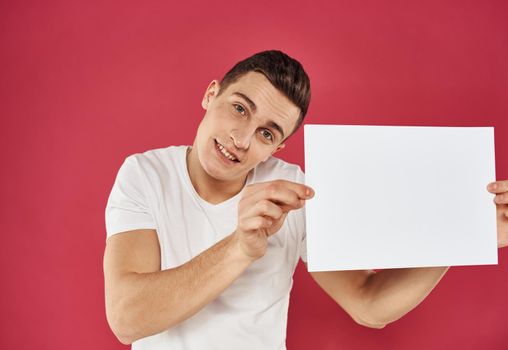 Man with a flyer in his hand on a red background advertising mockup Copy Space. High quality photo