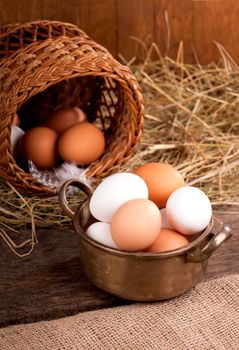 Chicken eggs in basket on grey wooden background