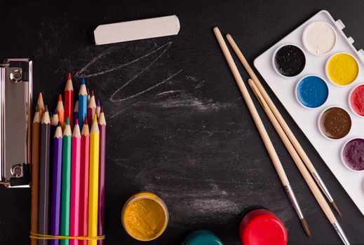 School supplies on blackboard background.