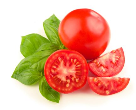 Tomatoes and basil leaves isolated on white close up.