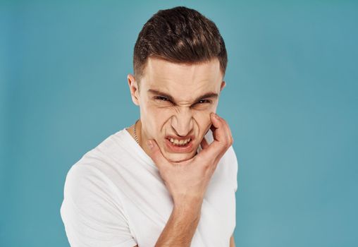 Man in white t-shirt studio close-up dissatisfaction. High quality photo