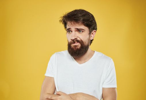 The man has his arms crossed over his chest against a yellow background cropped view. High quality photo