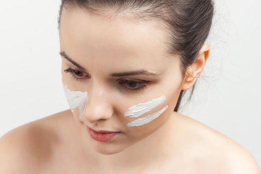 brunette with cream face mask bare shoulders smile. High quality photo