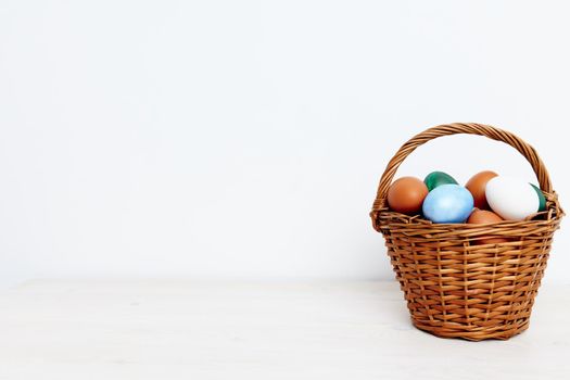 Easter eggs in a wicker basket on a Light background Copy Space. High quality photo