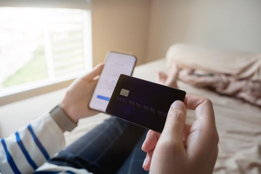 Online shopping payment,Woman's hands holding a smart phone and credit card and for online shopping at home.