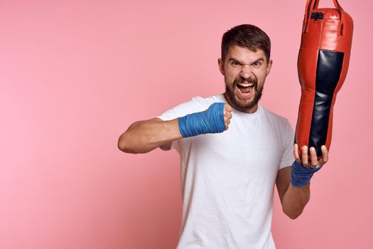 Sports man White T-shirt punching bag exercise gym. High quality photo