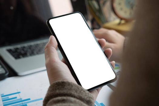 Woman using smartphone with blank screen for business financial work at home.