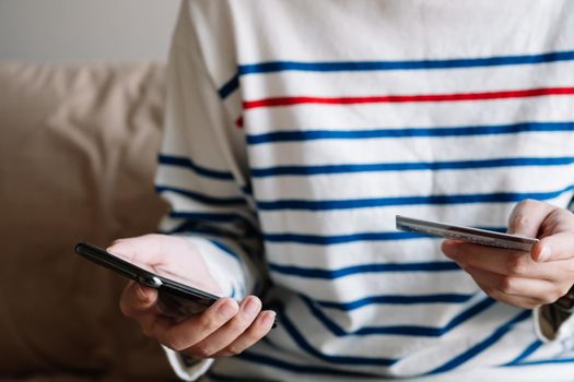 Online shopping payment,Woman's hands holding a smart phone and credit card and for online shopping at home