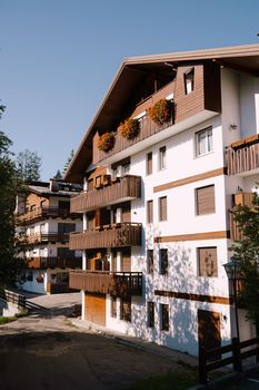 White whitewashed house, with wooden elements in northern Italy, in the Dolomites area, in a winter ski resort, in the city of Cortina Ampezzo.