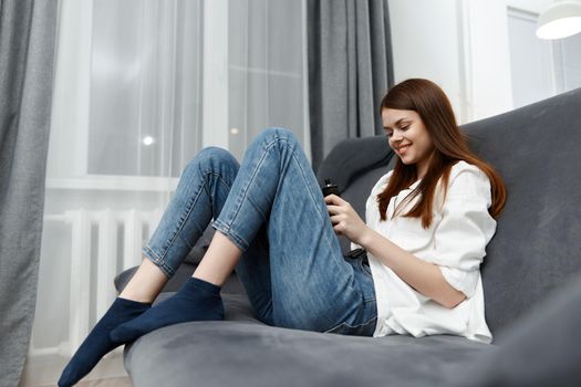 cheerful woman sitting on the couch at home rest interior. High quality photo