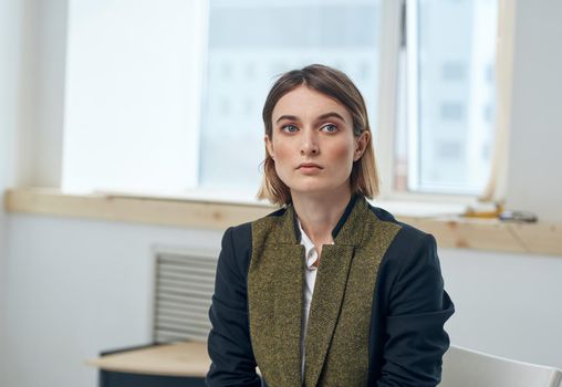 Business woman in suit near window in jacket portrait cropped view. High quality photo