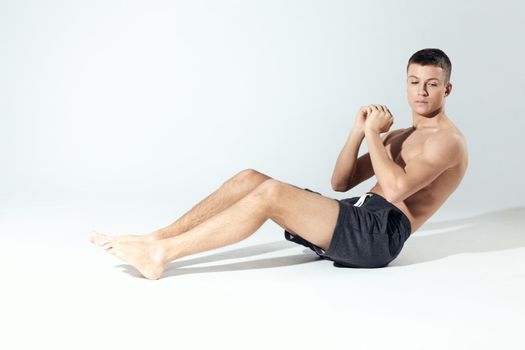 a man shakes the press In a bright room sitting on the floor in full growth on a light background. High quality photo