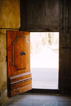 Old wooden door open from the insifr at the old villa in Italy, in Tuscany, near Florence.