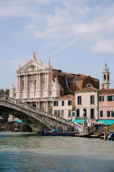 View from the water of the grand canal on the Scalzi Bridge and the Church of Scalzi. A very beautiful building with snow-white columns against blue sky with clouds in Venice, Italy