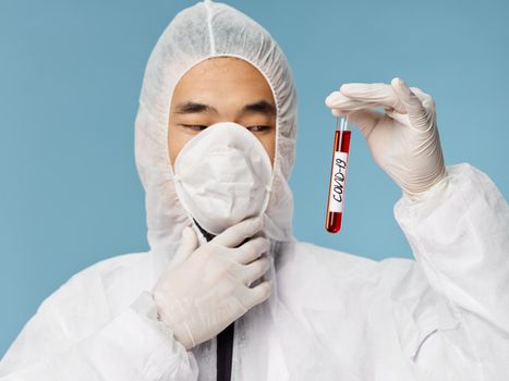Male laboratory assistant blood test covid-19 research biotechnology blue background. High quality photo