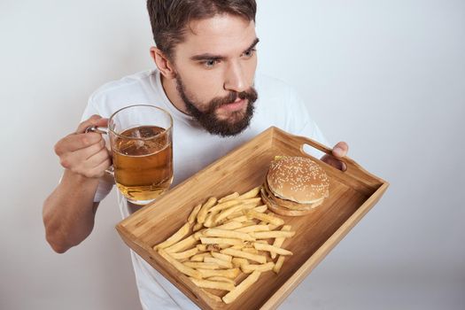 Man with a mug of beer fast food diet food alcohol fun light background. High quality photo