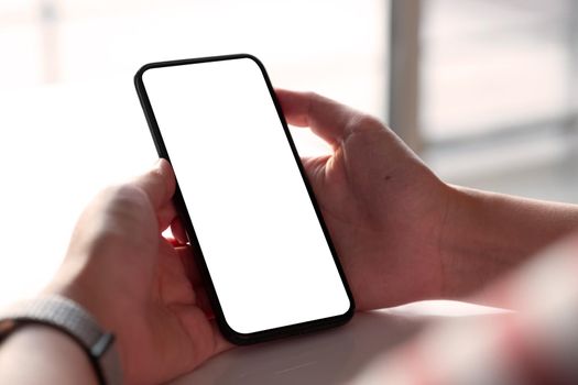 Woman holding blank screen mock up mobile phone.