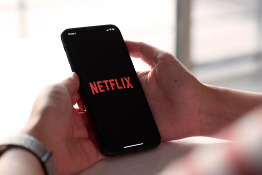 CHIANG MAI, THAILAND, NOV 17, 2019: Woman hand holding Smart Phone with Netflix logo on Apple iPhone Xs. Netflix is a global provider of streaming movies and TV series.