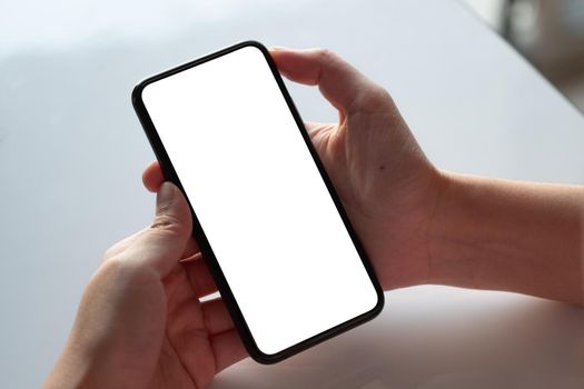 Top view Woman sitting and holding blank screen mock up mobile phone.