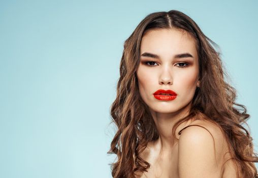 Sexy woman model on blue background cropped view of naked shoulders red lips. High quality photo