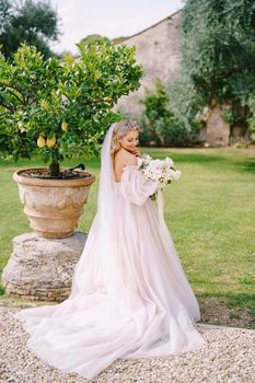 Wedding in Florence, Italy, in an old villa-winery. Bride with a bouquet in the garden, near the lemon tree.